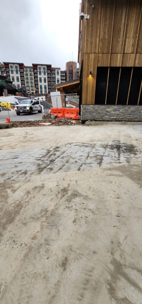 Worn bare concrete slab showing surface staining before diamond grinding